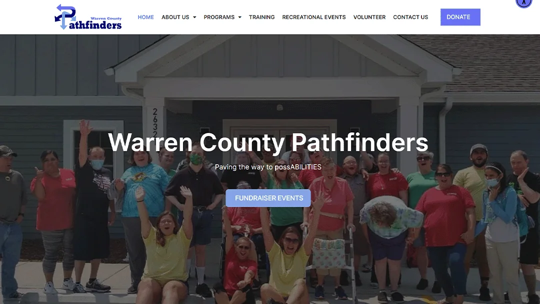 Homepage of Warren County Pathfinders, featuring a group of enthusiastic people gathered in front of a building. The text 
